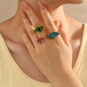 Detailaufnahme von drei Evil-Eye-Ringen mit farbigem Glas auf den Fingern des Modells