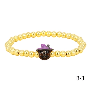 Close-up of Halloween beaded bracelet with golden beads and a pumpkin wizard charm