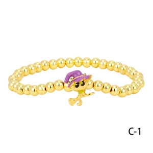Close-up of gold beaded bracelet featuring a purple wizard hat cat pendant for Halloween