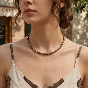 Bohemian semi-precious stone beaded necklace with gold accents worn by a model in warm light