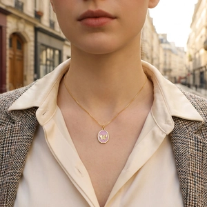 Detailansicht einer goldfarbenen Schmetterlingskette mit Emaille-Anhänger am Model