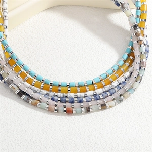 Dettaglio di collana a più strati con pietre naturali colorate e distanziatori in argento