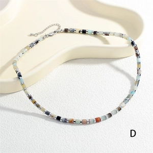 Dettaglio della collana di perline vivaci con distanziali in metallo e chiusura a moschettone