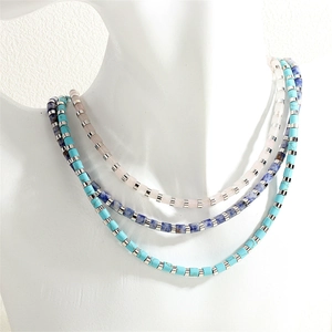 Primo piano della collana a tre strati con perle di pietra colorate su busto
