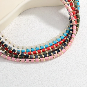 Close-up of handmade semi-precious stone necklace with colorful beads and gold spacers