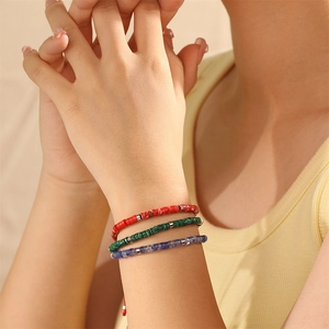 Detailweergave van drie handgemaakte kralenarmbanden met verstelbare rode koorden