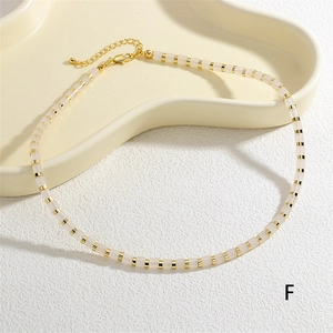 Detail of pink semi-precious stone beaded necklace with gold lobster clasp and chain