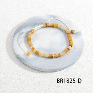 Detailopname van geweven armband met vierkante natuurstenen kralen en gouden accenten