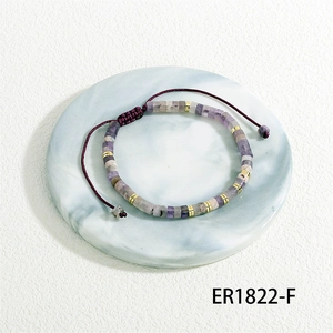 Detailed view of handmade woven bracelet with purple barrel beads and adjustable cord