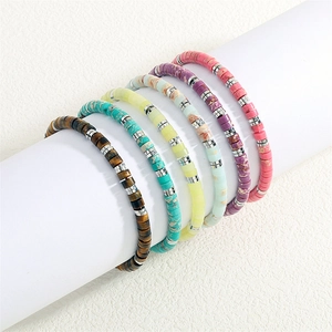 Macro shot of six colorful semi-precious stone beaded bracelets with silver spacers