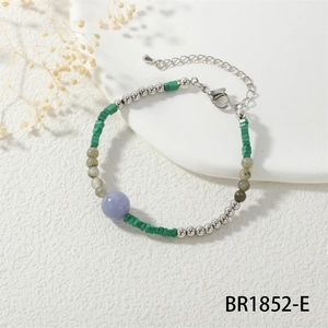 Detailopname van etnische kralenarmband met groene kubussen en paarse bolaccenten