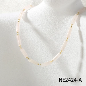 Close-up of handmade pink stone bead necklace with freshwater pearls and golden accents