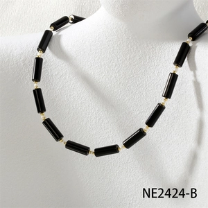 Detail of beaded necklace featuring black cylindrical beads and gold metallic accents