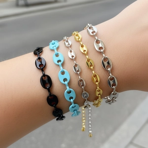 Dettaglio di braccialetti a maglie chicco di caffè colorati in oro argento e blu al polso