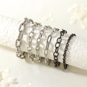 Detail shot of six industrial style metal chain bracelets in silver and gun black finishes
