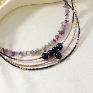 Close-up view of multi-strand beaded necklace with natural amethyst chips and pearls.