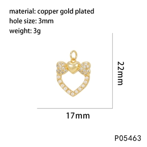 Macro detail of gold bow and heart pendant with sparkling cubic zirconia and pearls