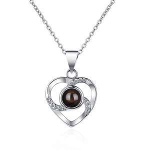 Silver-toned heart-shaped projection necklace with clear crystals on cross chain