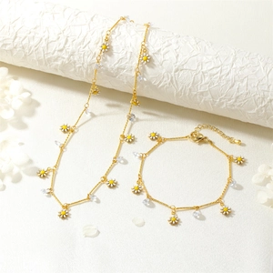 Elegant gold necklace and bracelet set featuring daisy charms and cubic zirconia drops