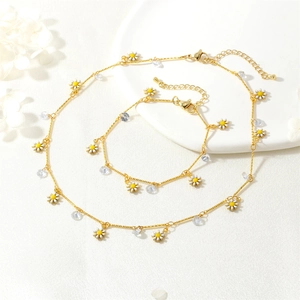 Detailed macro view of daisy charms and faceted zircon on golden necklace and bracelet