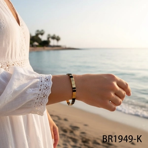 Gros plan détaillé du bracelet en perles Tila avec des blocs dorés et noirs au poignet