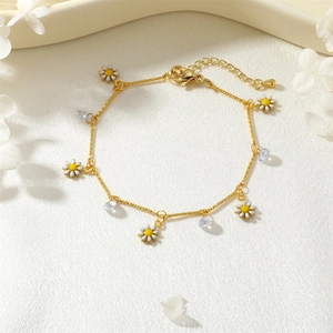 Detail of gold daisy bracelet with zircon charms on elegant beige silk background