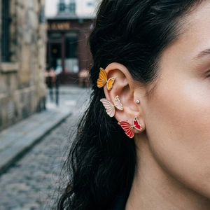Detail of butterfly earrings with colorful enamel wings and sparkling crystal accents