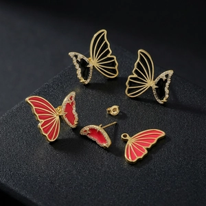 Elegant gold butterfly earrings set with red and black enamel wings and tiny crystals