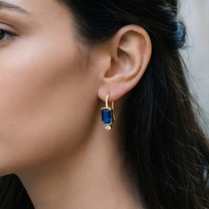 Vue détaillée des boucles d'oreilles avec pierre bleue taille émeraude et cristaux