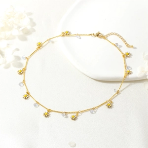 Detail of gold daisy necklace with white enamel petals and clear crystal beads