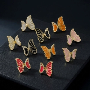 Detailed macro of gold butterfly earrings with enamel wings and micro-paved zircons