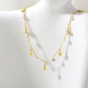 Detail of gold necklace with white daisy enamel petals and faceted zircon crystals