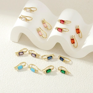 Collection de boucles d'oreilles en zircone colorée sur des socles texturés blancs