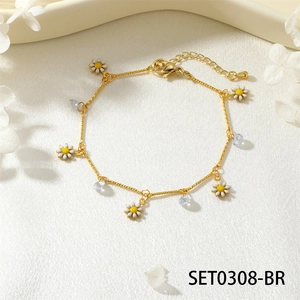 Elegant gold daisy bracelet with cubic zirconia charms on ivory silk fabric background