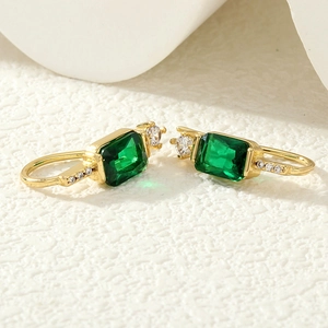 Gros plan de boucles d'oreilles vintage en zircon vert émeraude avec placage en or
