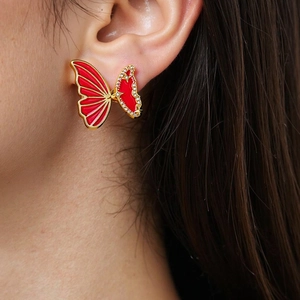 Macro view of butterfly stud earrings with red enamel and shimmering zirconia stones