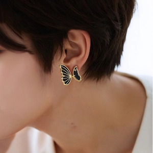 Detail of luxury butterfly earring featuring gold plating, black enamel, and micro-inlaid zircons