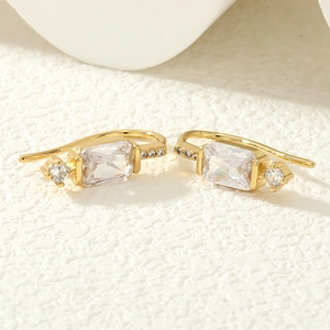 Gros plan détaillé de boucles d'oreilles dorées avec cristaux de zircon rectangulaires
