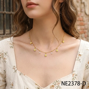 Collana dorata con margherite bianche e cristalli a goccia indossata da modella