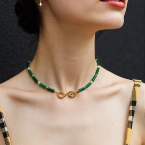 Close-up of emerald beaded necklace with snake element and white pearl accents