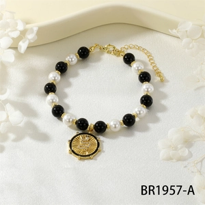 Macro shot of boho snake charm bracelet with black beads, pearls and gold finish