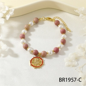 Detailed macro view of snake coin charm on pearl and natural stone beaded bracelet