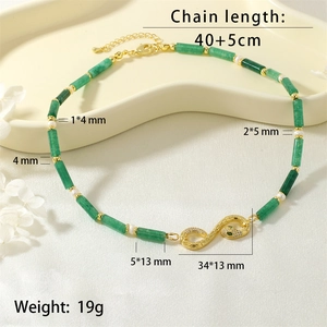Detail view of emerald stone necklace with pearl beads and sparkling snake pendant charm