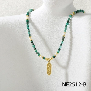 Close-up of emerald beaded necklace with gold dragon pendant and pearls on model neck