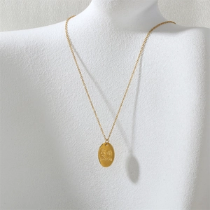 Vue détaillée du collier doré avec pendentif ovale gravé You are my sunshine