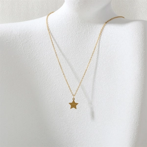 Vue détaillée du pendentif étoile dorée avec gravure love sur un collier minimaliste