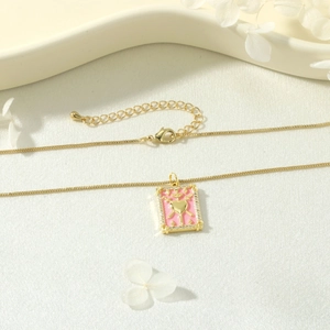 Detail of pink enamel tarot pendant necklace with gold heart and zircon border