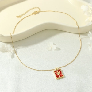 Detail view of 18K gold plated tarot card necklace with red enamel heart and zircon inlay