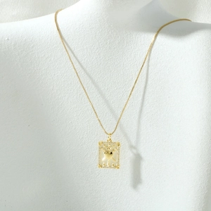 Close-up of gold tarot card necklace featuring a heart and swords pendant with zircon stones