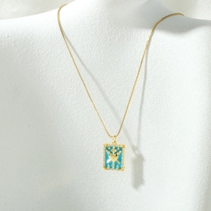Detail of 18K gold-plated tarot card necklace with light blue enamel and zircon inlay